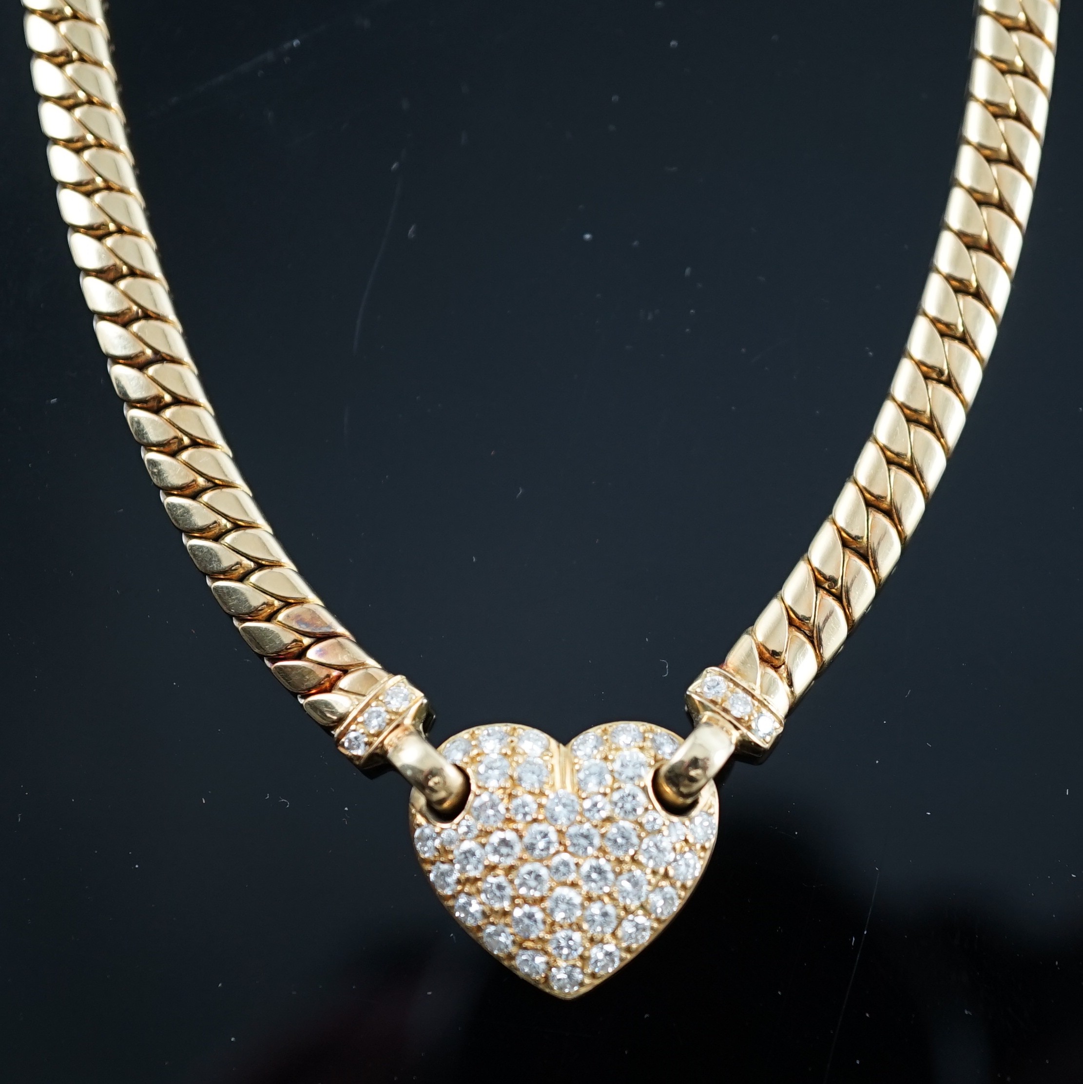 A modern 18ct gold and pave set diamond heart shaped pendant necklace